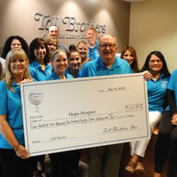 The Toll Brothers holding a check for $102,188 for Hope Hospice at charity Golf Castlewood Country Club