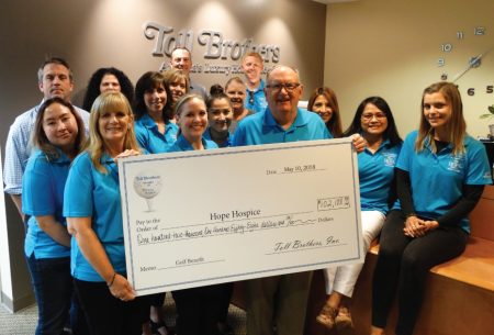 The Toll Brothers holding a check for $102,188 for Hope Hospice at charity Golf Castlewood Country Club