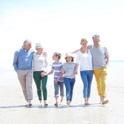 multigenerational family walking on beach