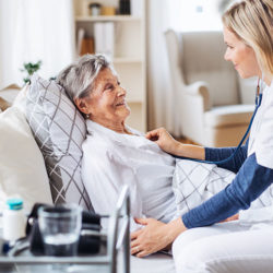 home visit nurse checking on female senior patient