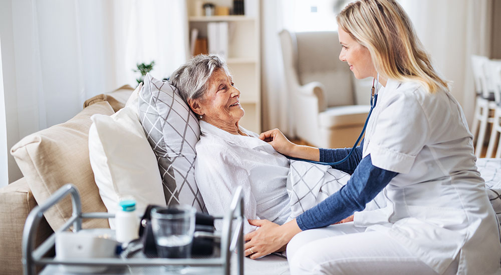 home visit nurse checking on female senior patient