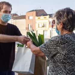 male delivers groceries to elderly woman
