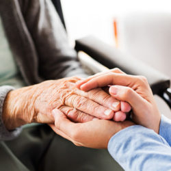 man holding elderly woman's hands